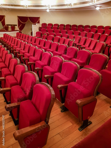 Close-up of traditional, classic empty chairs upholstered in red velvet, the interior of the theater