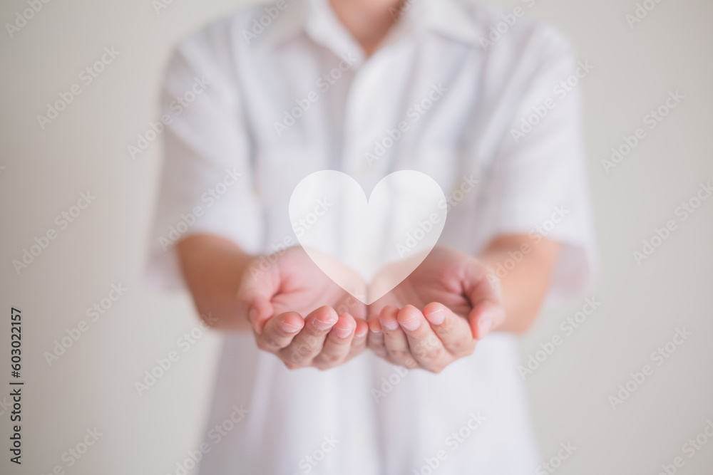 Hands holding a white heart. Concept of heart health insurance, health care, love, organ donation, world heart day, world health day, donation charity, Valentine day. Hands holding a white heart. Concept of heart health insurance, health care, love, organ donation, world heart day, world health day, donation charity, Valentine day.