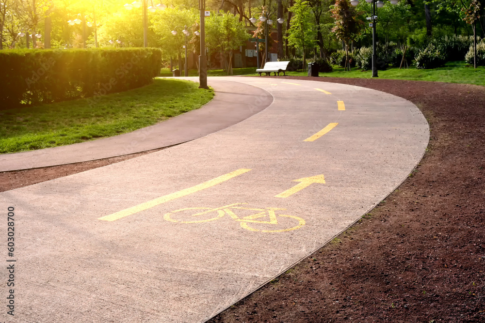 Obraz premium Highlighted with yellow paint cycle path in the city park.