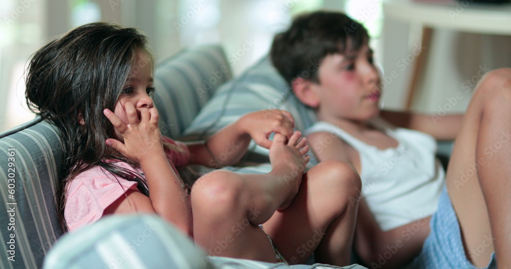Authentic siblings watching movie or cartoon on TV Authentic siblings watching movie or cartoon on TV