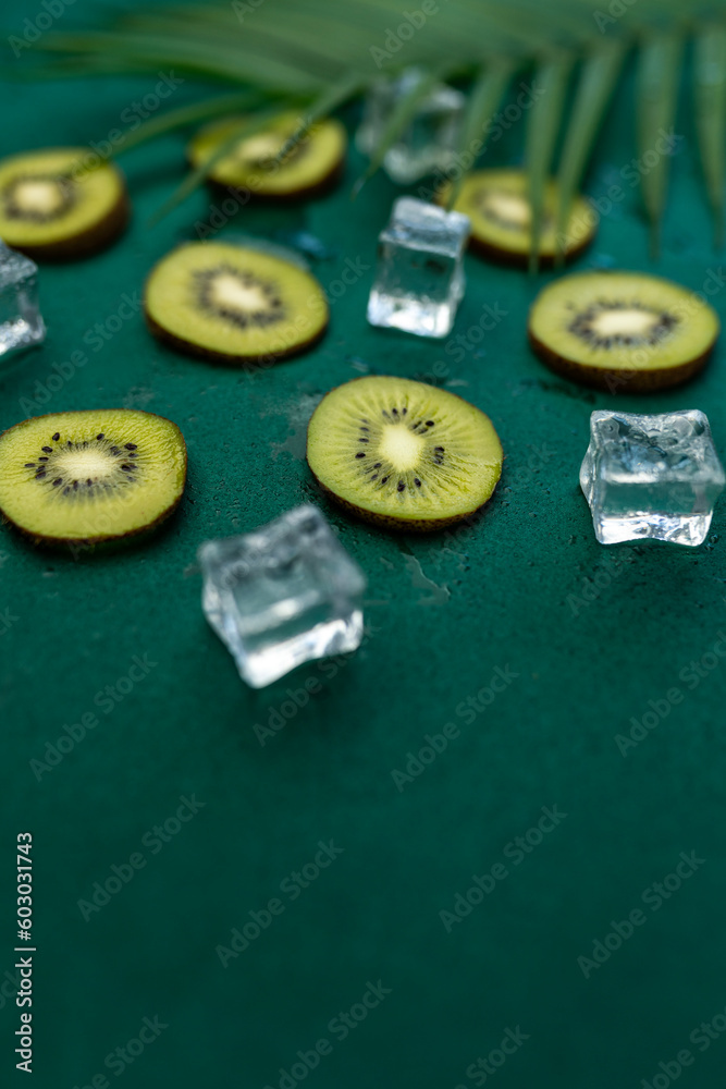 Sliced kiwi fruits with ice cubes, creative fruit background Sliced kiwi fruits with ice cubes, creative fruit background