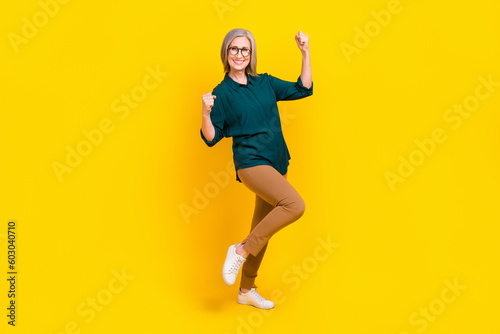 Full size photo of broker lawyer aged lady winning job promotion raise fist up isolated bright color background