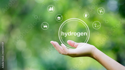 Hydrogen energy, environment, industry, nature and alternative energy. Green energy future connected icon in hand on green background.