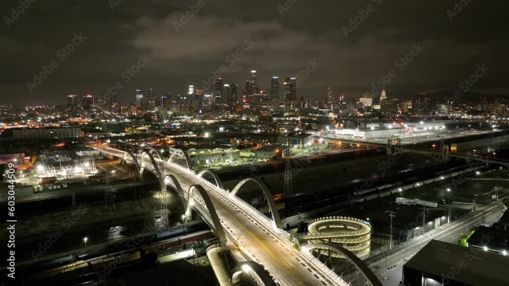 Aerial shot of downtown Los Angeles at night. the 6th street bridge and the LA River can be seen.