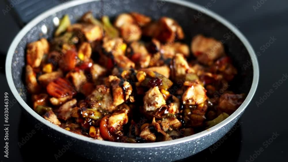 The chef pours sauce on vegetables with meat that is stewed in a pan. Cooking in a restaurant's kitchen. The chef pours sauce on vegetables with meat that is stewed in a pan. Cooking in a restaurant's kitchen.