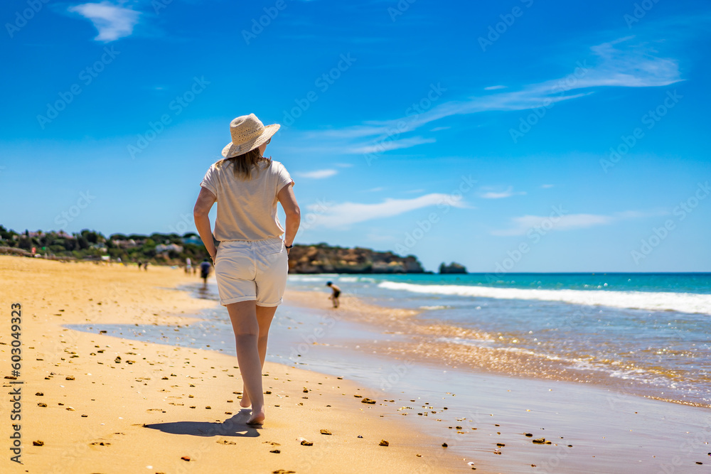Beautiful woman walking on sunny beach
