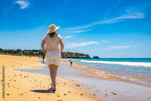 Beautiful woman walking on sunny beach