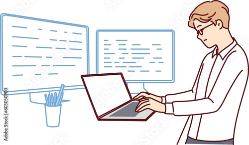Man software developer is standing at table with laptop and monitors creating server applications