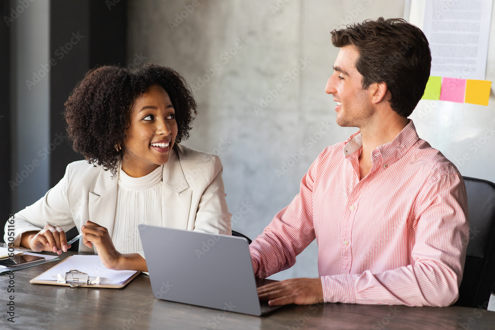 Happy multiracial coworkers have conversation during work meeting, office interior Happy multiracial coworkers have conversation during work meeting, office interior