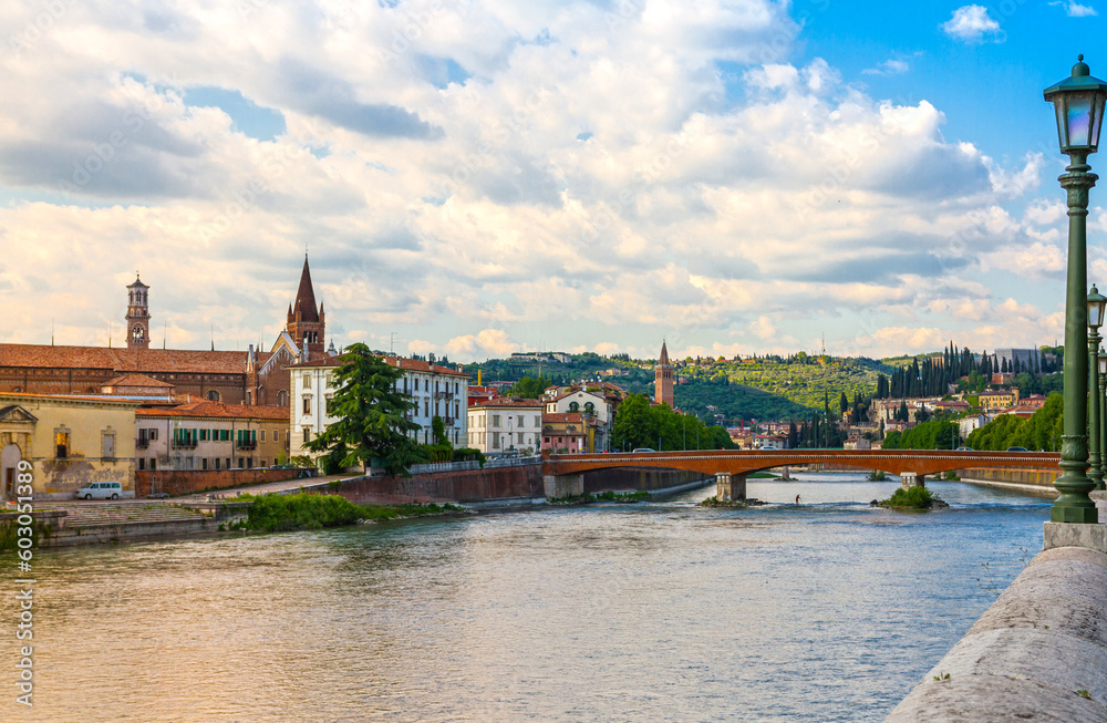 Panorama of old Verona with colorful buildings, channel and bridge under the cloudy sky