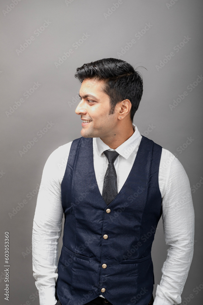 Studio shot of cheerful, young, handsome Indian business man in formal wear against grey background. Male model. Fashion Portrait. Studio shot of cheerful, young, handsome Indian business man in formal wear against grey background. Male model. Fashion Portrait.