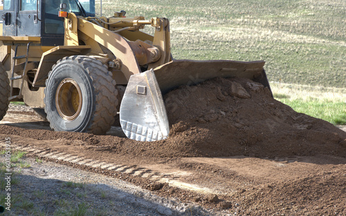 Large industrial front end loader moving road mix.