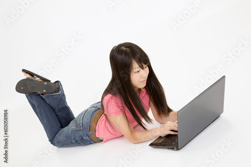 Portrait of Asian teenager working with a laptop conputer on a white background photo