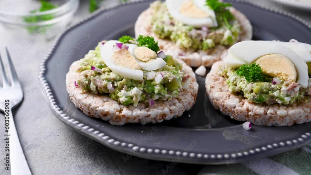 Avocado tuna salad on rice cakes with red onions and boiled egg. 