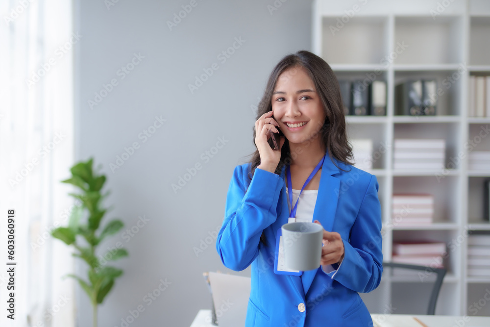 Happy beautiful smiling Asian businesswoman talking on mobile phone while working in office. Asian businesswoman making telephone call at office , enjoying talk, communication Happy beautiful smiling Asian businesswoman talking on mobile phone while working in office. Asian businesswoman making telephone call at office , enjoying talk, communication