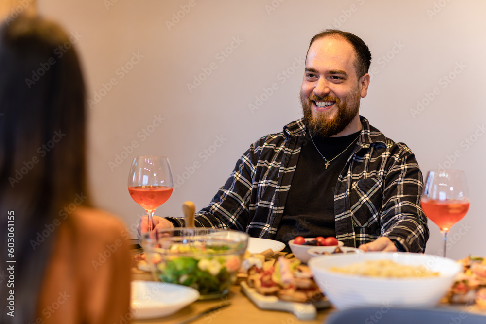 Couple having intimate dinner, focus on the man, uplifting smile. Couple having intimate dinner, focus on the man, uplifting smile.