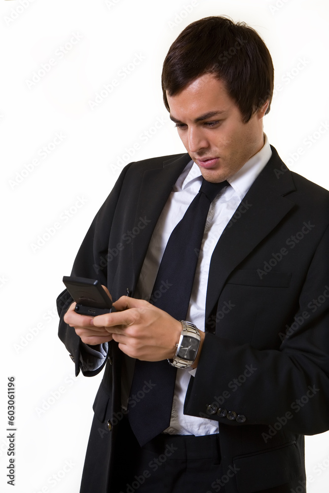 Handsome brunette young business man wearing business suit with blue tie text messaging Handsome brunette young business man wearing business suit with blue tie text messaging
