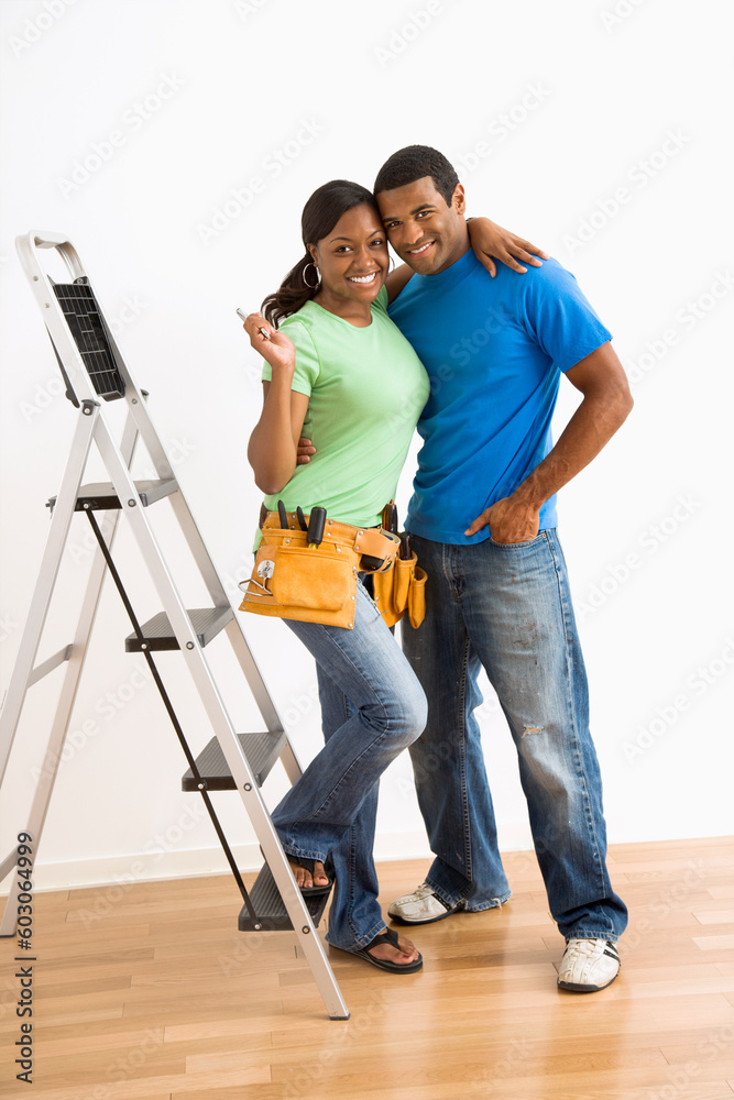 Portrait of smiling African American male and female couple with home repair tools and ladder. Portrait of smiling African American male and female couple with home repair tools and ladder.