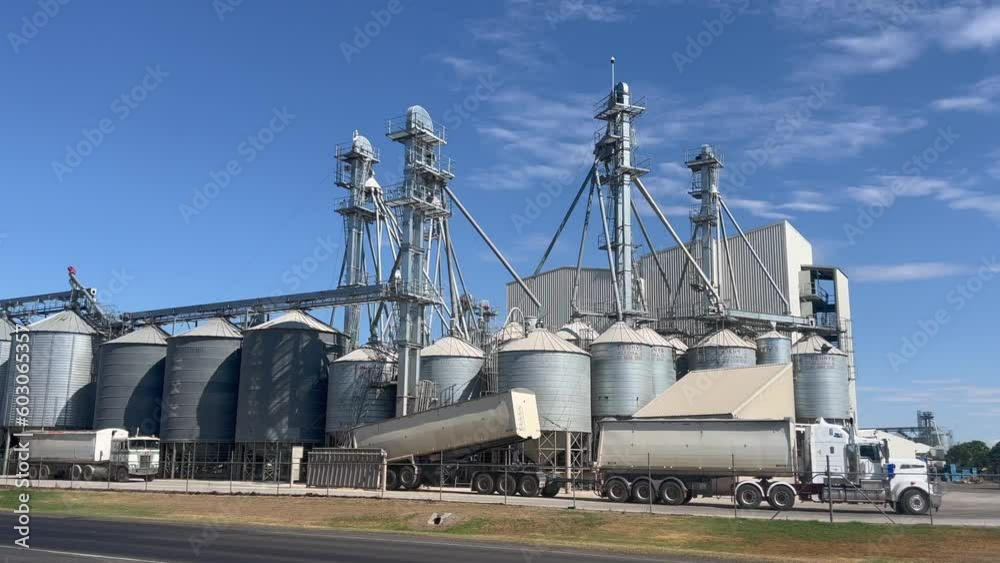 Trucks loading grain from silos in a plant in Queensland, Australia. Trucks loading grain from silos in a plant in Queensland, Australia.
