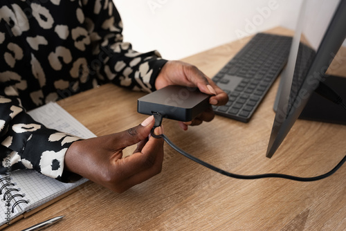 Black woman using portable external hard drive photo