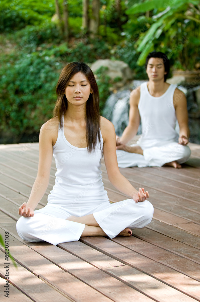 A young couple doing yoga outside A young couple doing yoga outside