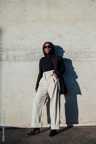 Woman in black blazer and trousers posing during sunset photo