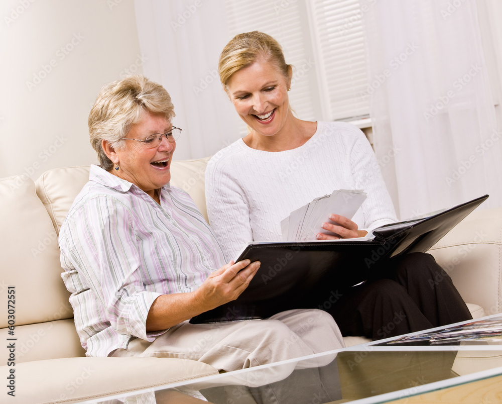Senior woman and daughter looking at photographs Senior woman and daughter looking at photographs