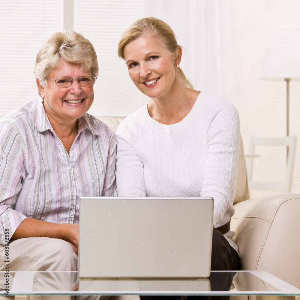 Senior woman and daughter using laptop