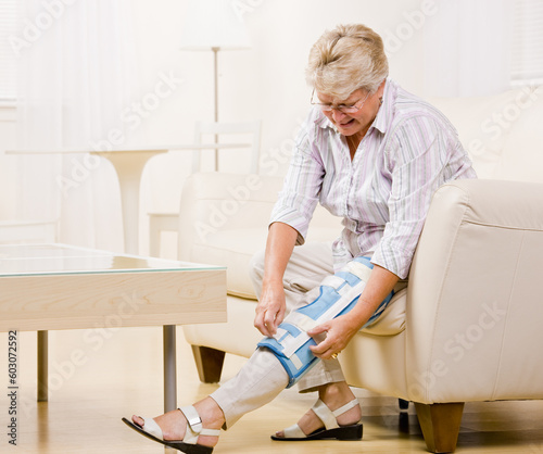 Senior woman adjusting knee brace photo