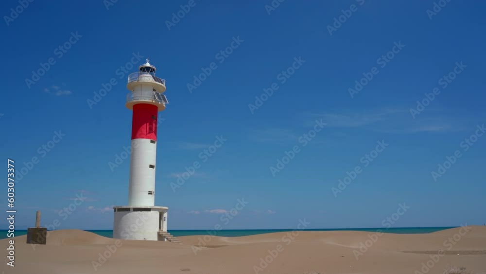 Lighthouse in Fangar Beach in Delta del Ebro in a sunny day with Mediterranean Sea in the background Lighthouse in Fangar Beach in Delta del Ebro in a sunny day with Mediterranean Sea in the background