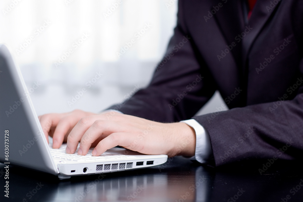 Businessman typing on a notebook (shallow DOF, hand in focus) Businessman typing on a notebook (shallow DOF, hand in focus)