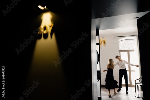 Joyful couple performing dance in hotel room
 photo