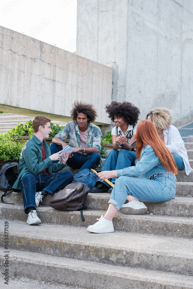 Group of university students sitting on some stairs of the college in the open air. Concept: education, friendship, together Group of university students sitting on some stairs of the college in the open air. Concept: education, friendship, together