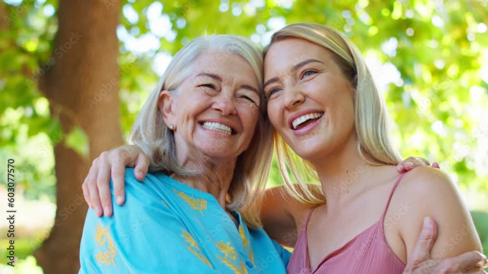 Multi-generation family with senior mother and adult daughter standing outside in garden, park or countryside laughing together- shot in slow motion Multi-generation family with senior mother and adult daughter standing outside in garden, park or countryside laughing together- shot in slow motion
