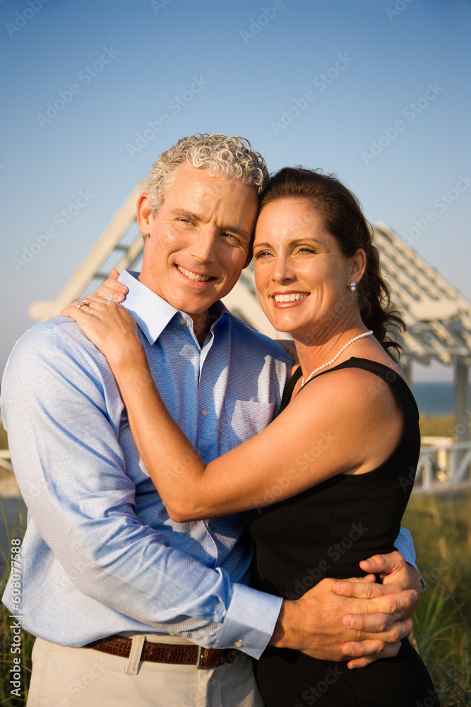Affectionate couple on beach with their arms around one another. Vertical shot. Affectionate couple on beach with their arms around one another. Vertical shot.