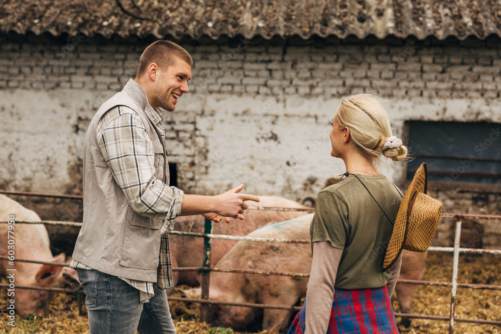 A man and a woman stand next to a pg stall and talk. A man and a woman stand next to a pg stall and talk.