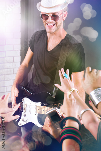 A guitarist performing for his adoring fans at  dico club or party photo