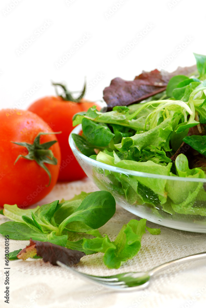 Fresh baby greens salad and tomatoes on white background Fresh baby greens salad and tomatoes on white background
