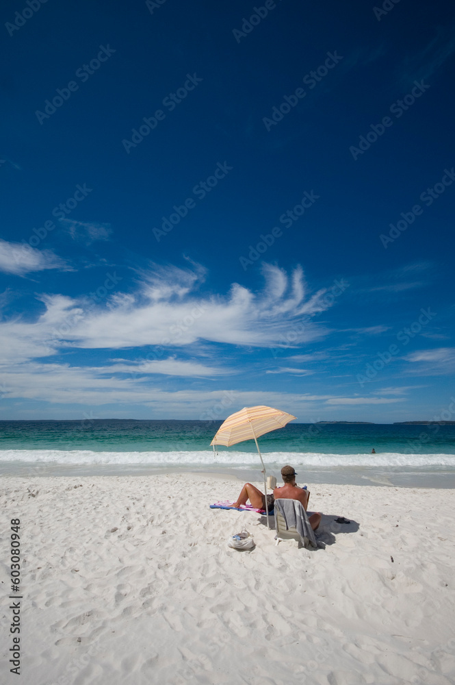 couple sitting on a tropical beach under an umbrella