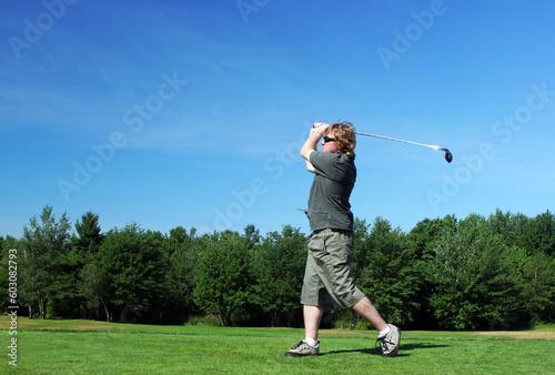 Man tees off at the golf course.