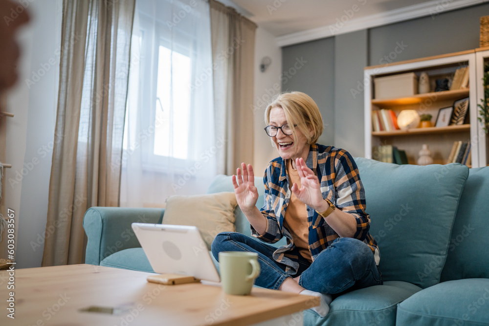 One mature blonde woman use digital tablet for video call at home One mature blonde woman use digital tablet for video call at home