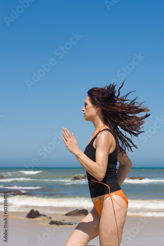 Fototapeta Naklejka Na Ścianę i Meble -  Athletic model running fast on the beach