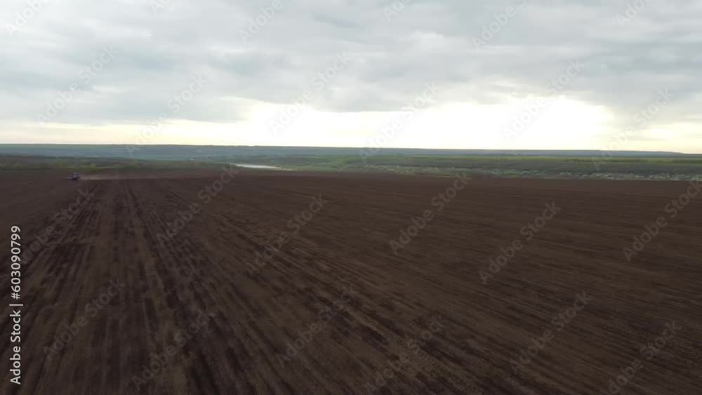 Blue tractor with yellow seeder working on the field in Ukraine OA Blue tractor with yellow seeder working on the field in Ukraine OA