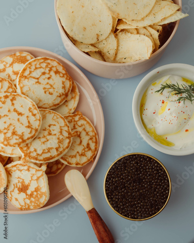 Caviar, chips, crème fraîche and blinis on blue background
, 