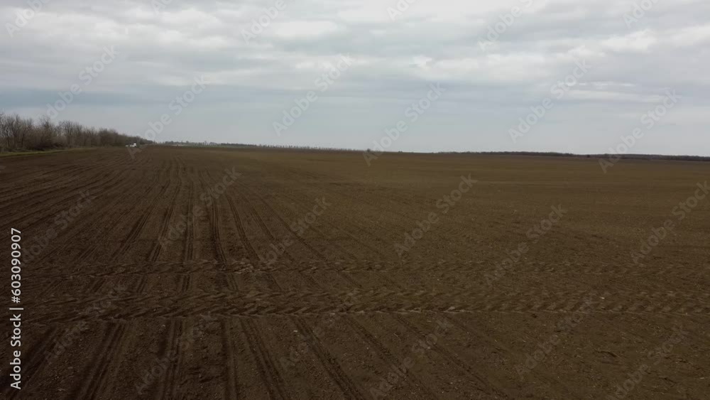 Blue tractor with yellow seeder working on the field in Ukraine OA Blue tractor with yellow seeder working on the field in Ukraine OA