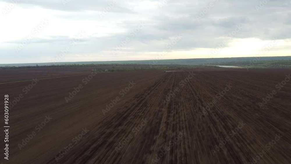 Blue tractor with yellow seeder working on the field in Ukraine OA Blue tractor with yellow seeder working on the field in Ukraine OA