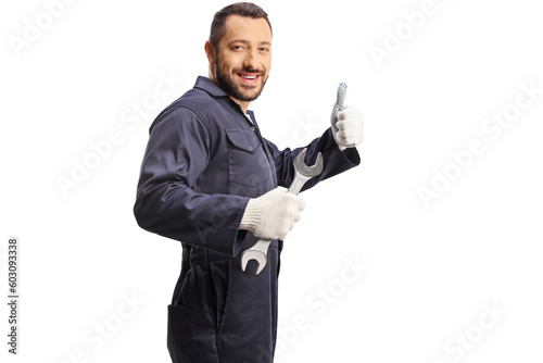 Car mechanic holding a wrench and showing a thumb up sign photo