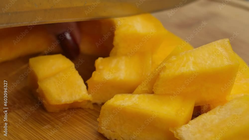 Knife cuts pumpkin slices into square pieces Knife cuts pumpkin slices into square pieces