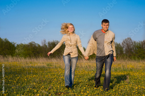 Happy couple walk across the field