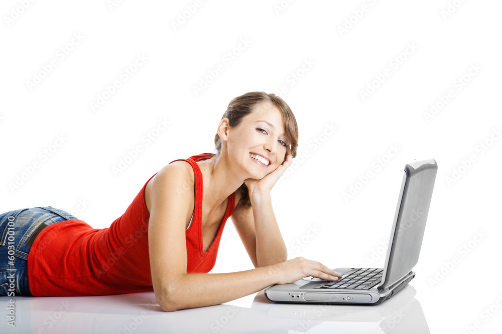 Beautiful and happy young woman lying on floor and working on a laptop Beautiful and happy young woman lying on floor and working on a laptop
